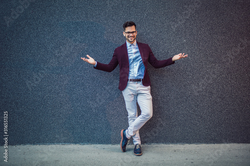 Portrait of modern young smiling businessman outdoor.