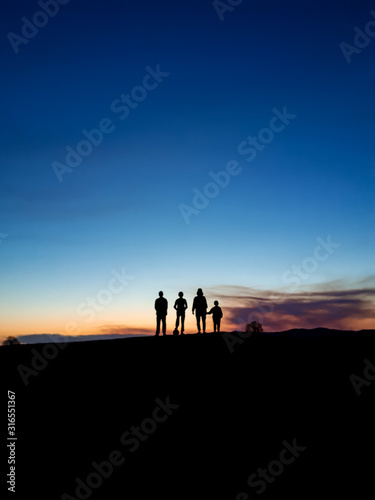 silhouette of people on top of the mountain at sunset