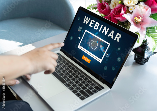 Person using a laptop computer for online training webinars. E-learning browsing connection and cloud online technology webcast concept. Laptop mockup with clipping path on screen. © RoBird