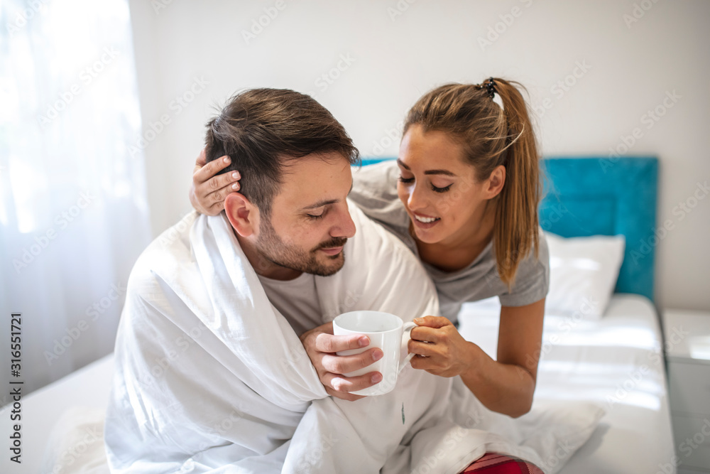 Trying to get warm. Cheerless sad man sitting with a cup of hot tea while trying to get warm. You will get better. Nice caring wife sitting near her ill husband while supporting him Trying to get warm. Cheerless sad man sitting with a cup of hot tea while trying to get warm. You will get better. Nice caring wife sitting near her ill husband while supporting him