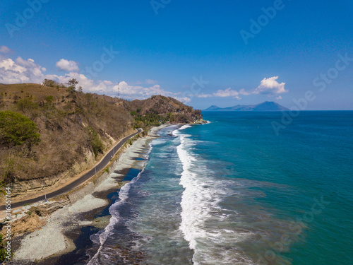 Aerial view ocean shoreline and parallel road. Famous Blue Stone beach near Ende, Flores island, East Nusa Tenggara, Indonesia