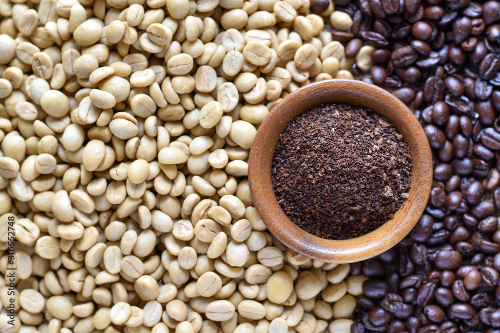 High angle view, White dried coffee beans and roasted coffee beans with powder coffee in wooden bowl. High angle view, White dried coffee beans and roasted coffee beans with powder coffee in wooden bowl.