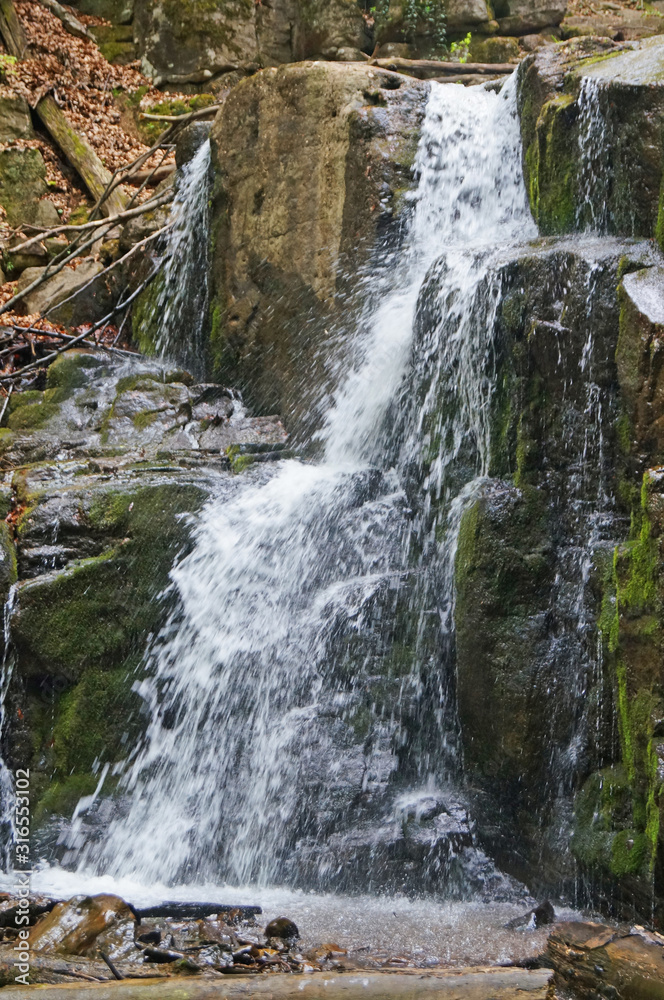 Skakalo waterfall in the Carpathian mountains surrounded by forest on a spring sunny day