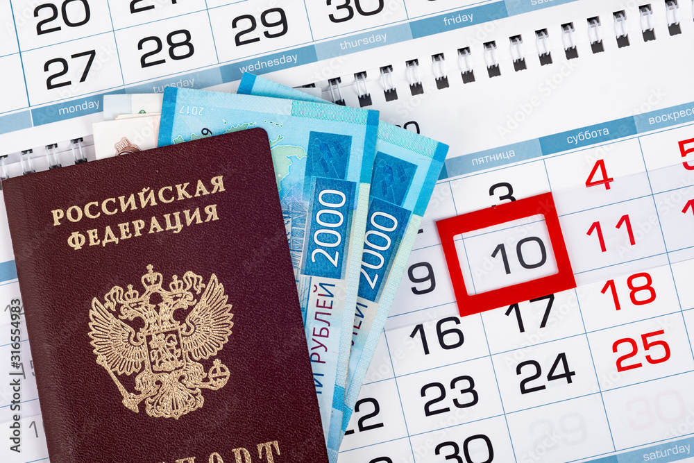 Passport and two 2,000 bills are on the calendar Passport and two 2,000 bills are on the calendar