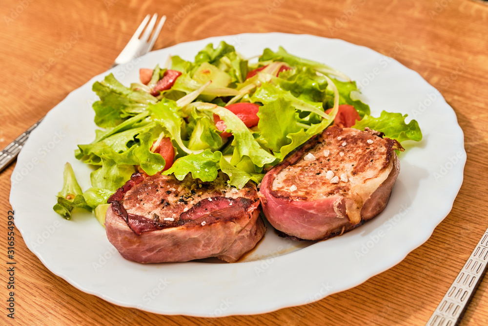 Pork tenderloin in dried ham  steak with salad