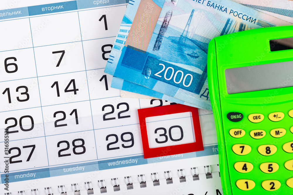 Obraz premium Calendar with a allocated 30 number, Russian two two-thousand bills, calculator