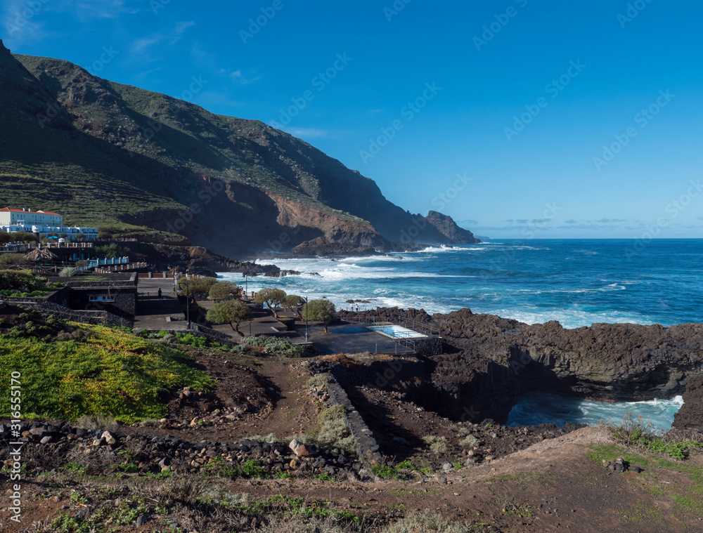 View on La Fajana with natural sea swimming pools and waves of atlantic ocean, sunny day. La Palma, Canary Islands, Spain