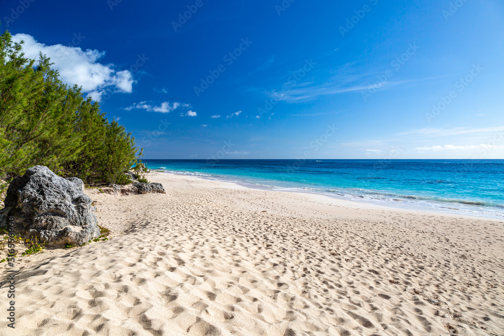 Looking along the idyllic Elbow Beach on the island of Bermuda, with a blue sky overhead