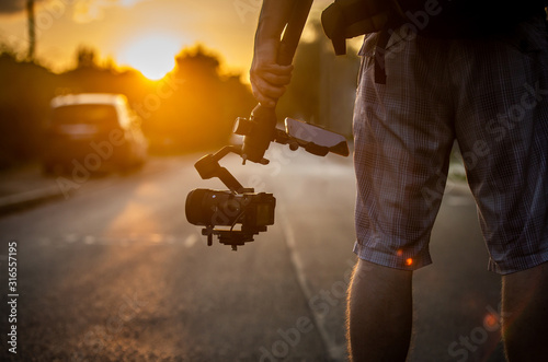 Man holding gimbal with sunset view. photo