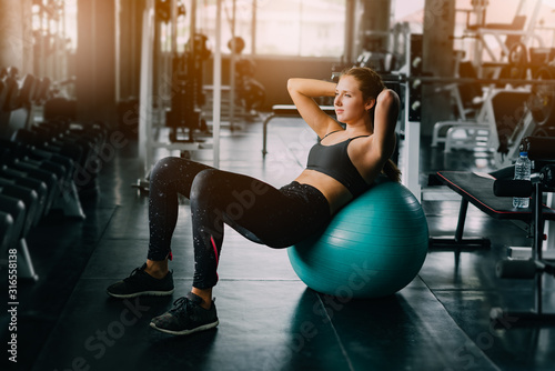 Young fitness woman execute exercise with exercise-machine in gym, horizontal photo.Doing Workout Exercises.Relaxing After Fitness Training in gym.Sports concept fat burning,wellness and healthy.