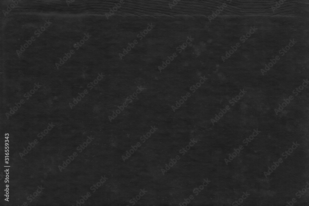Cardboard black abstract texture close-up. Dark old paper background. Grunge concrete wall. Vintage blank wallpaper.