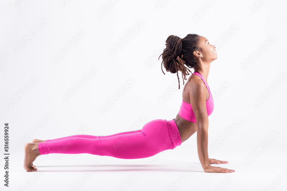 Pretty young black woman doing yoga exercise isolated on white background Pretty young black woman doing yoga exercise isolated on white background