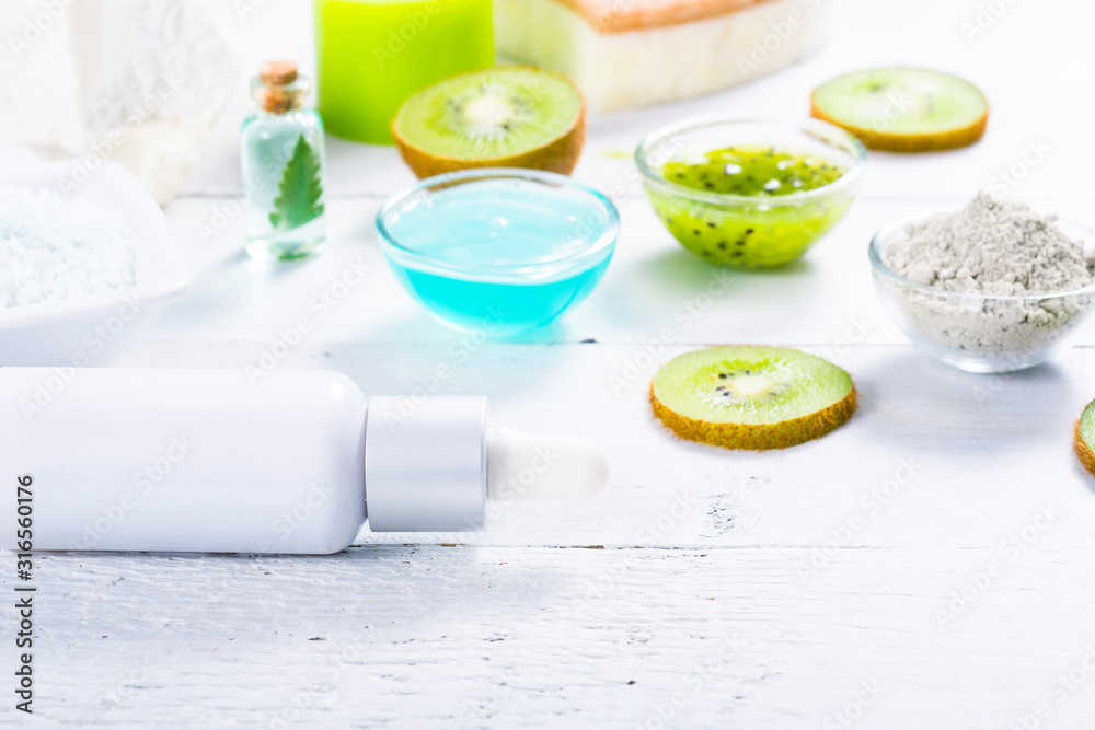beauty products with kiwi fruit ingredient on white wooden table