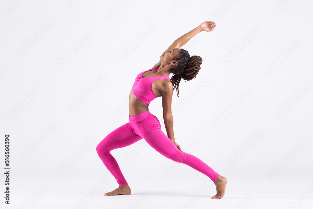 Pretty young black woman doing yoga exercise isolated on white background Pretty young black woman doing yoga exercise isolated on white background