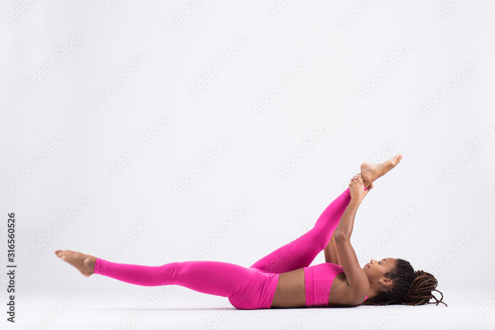 Pretty young black woman doing yoga exercise isolated on white background Pretty young black woman doing yoga exercise isolated on white background