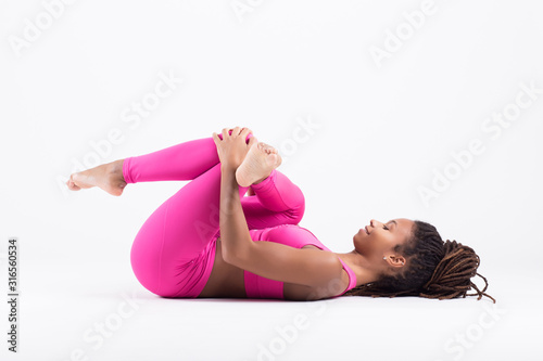 Pretty young black woman doing yoga exercise isolated on white background