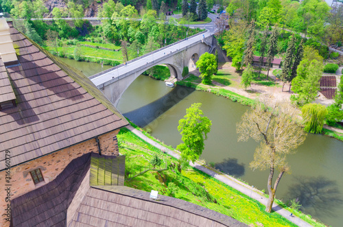 Bridge over Eger river top aerial view from walls of Loket Castle Hrad Loket gothic style building on massive rock  green grass and trees  Karlovy Vary Region  West Bohemia  Czech Republic