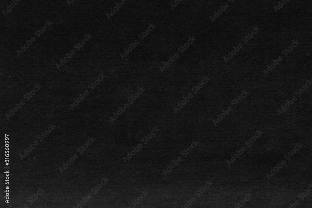 Cardboard black abstract texture close-up. Dark old paper background. Grunge concrete wall. Vintage blank wallpaper.