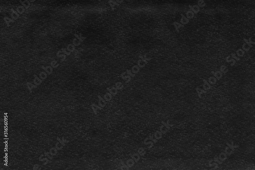 Cardboard black abstract texture close-up. Dark old paper background. Grunge concrete wall. Vintage blank wallpaper.