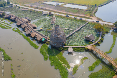 Giant fish trap and long bamboo bridge with many beautiful lotus at Sapan Khong Floating Market, a new tourist attraction in Suphan Buri, Thailand. photo