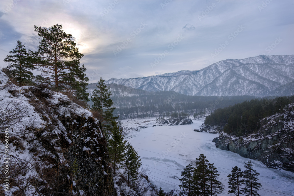 Landscape with snow-capped mountains and a freezing mountain river Landscape with snow-capped mountains and a freezing mountain river