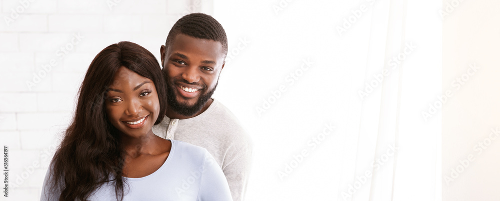 Cheerful young married couple posing over white background - obrazy, fototapety, plakaty 