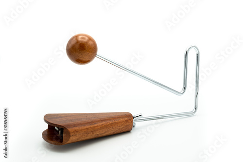 фотографія A vibraslap silver, brown wood on white underground