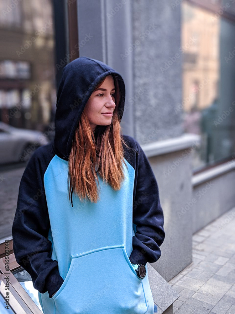 Girl in a long hoodie. Sweater is dark blue with blue. Raglan. Street  Fashion. Urban. Stock-Foto | Adobe Stock