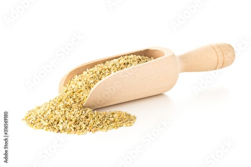 Heap of uncooked, raw freekeh or firik, roasted wheat grain, in wooden scoop over white