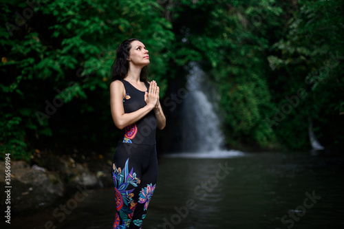 Yoga practice and meditation in nature. Woman practicing near river