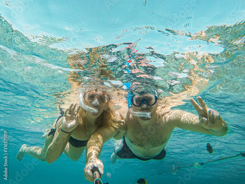 Young couple snorkeling selfie underwater camera on the coral reef in ocean of Egypt Hurghada travel concept vacation photo