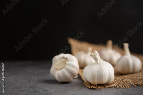 Garlic on the black cement floor and black background.