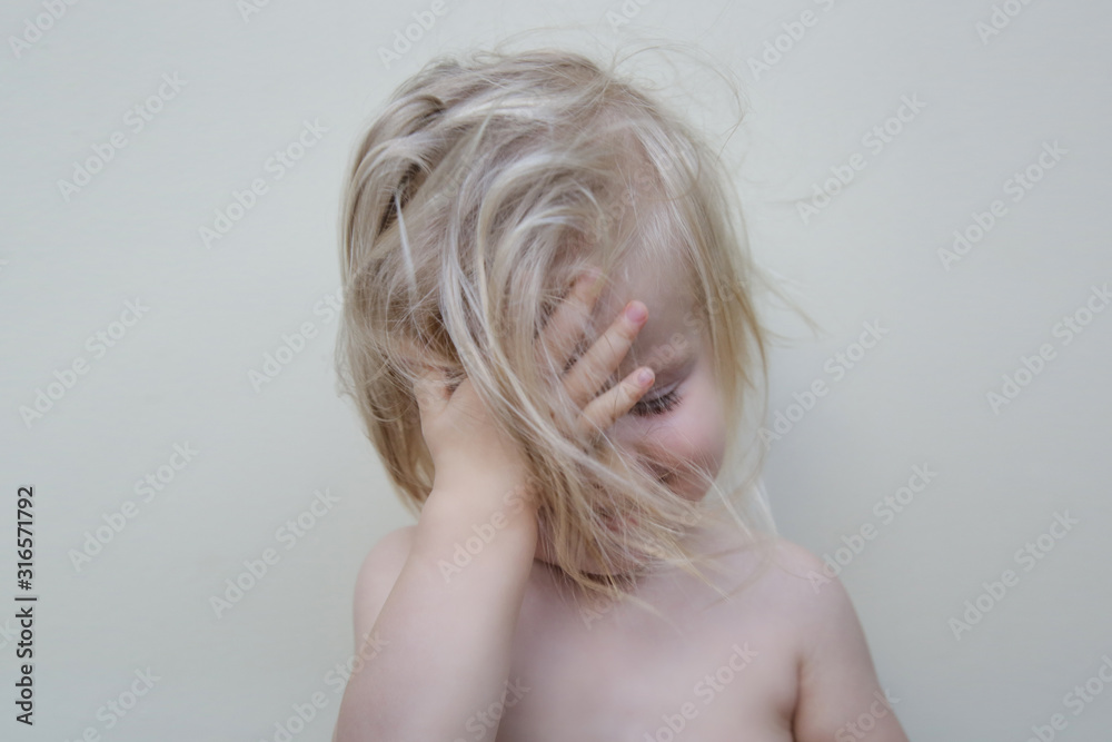 Candid portrait of adorable blonde toddler girls with blue eyes and messy hair Candid portrait of adorable blonde toddler girls with blue eyes and messy hair