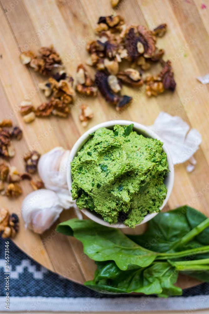 Green Italian pesto - traditional dip paste sauce with walnuts, garlic and basil leaves. Vegan food. Green Italian pesto - traditional dip paste sauce with walnuts, garlic and basil leaves. Vegan food.