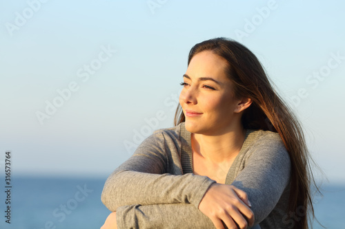Confident woman watching sunset on the beach © PheelingsMedia