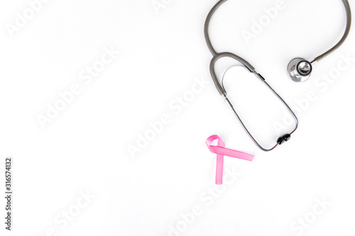 Flat layout of a pink ribbon besides a stethoscope