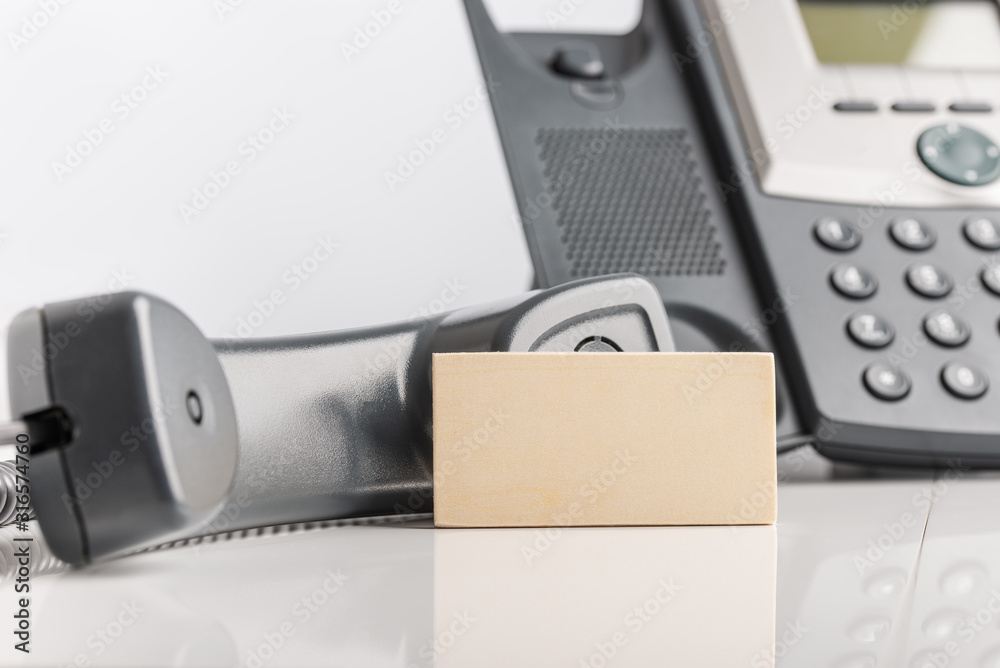 Blank business card next to landline telephone Blank business card next to landline telephone