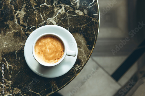 Top view of a cup of fresh aromatic morning coffee on a marble table photo