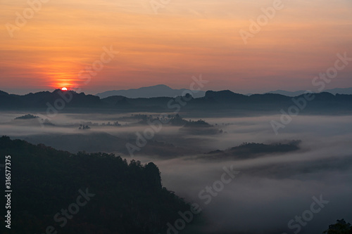 Beautiful sunrise and colorful sky in the mist over the mountain