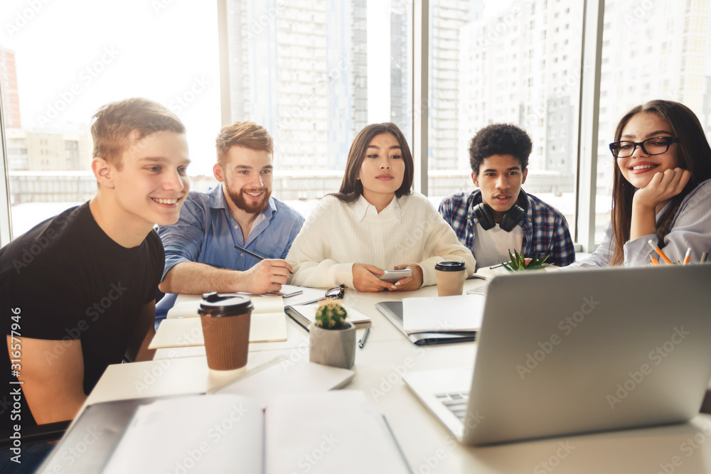 Skilled young programmers watching webinar on laptop computer