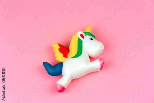 top view squishy unicorn toy on a pastel pink background photo
