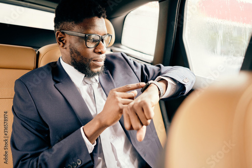 Man looks at his apple watch while being in the car.