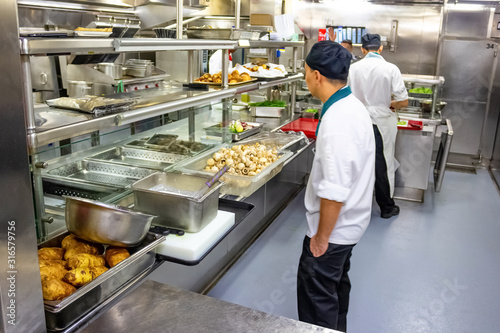 Obraz na plátně Kitchen crew work in the galley of a cruise ship in the Caribbean Sea
