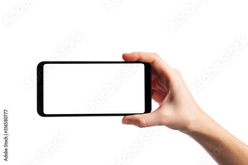 Woman holding smartphone with empty screen isolated on white background. Female hand with phone, space for text