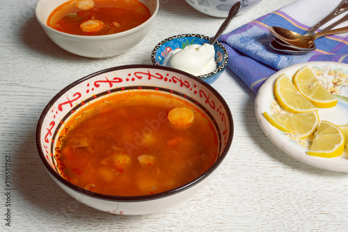 Rustic bowl with hodgepodge meat soup made of various kind of meat, sausages and vegetables 