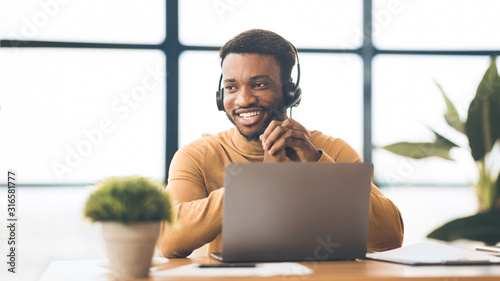 Happy afro manager working in call centre
