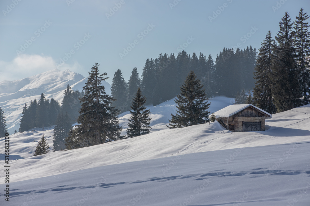 Mountain huts in a snowy landscape in the swiss Alps, Switzerland, Europe