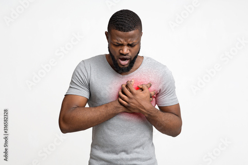 Black man having heart attack, holding his chest