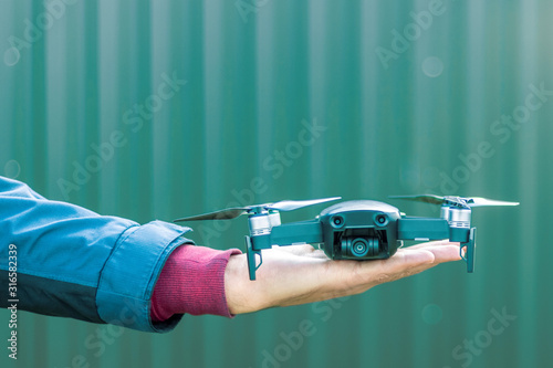 Drone on a male palm is ready to take a flight.