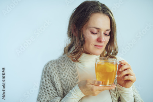 sick elegant 40 years old housewife drinking cup of tea